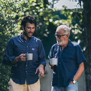 An adult hipster son and senior father at home, talking.